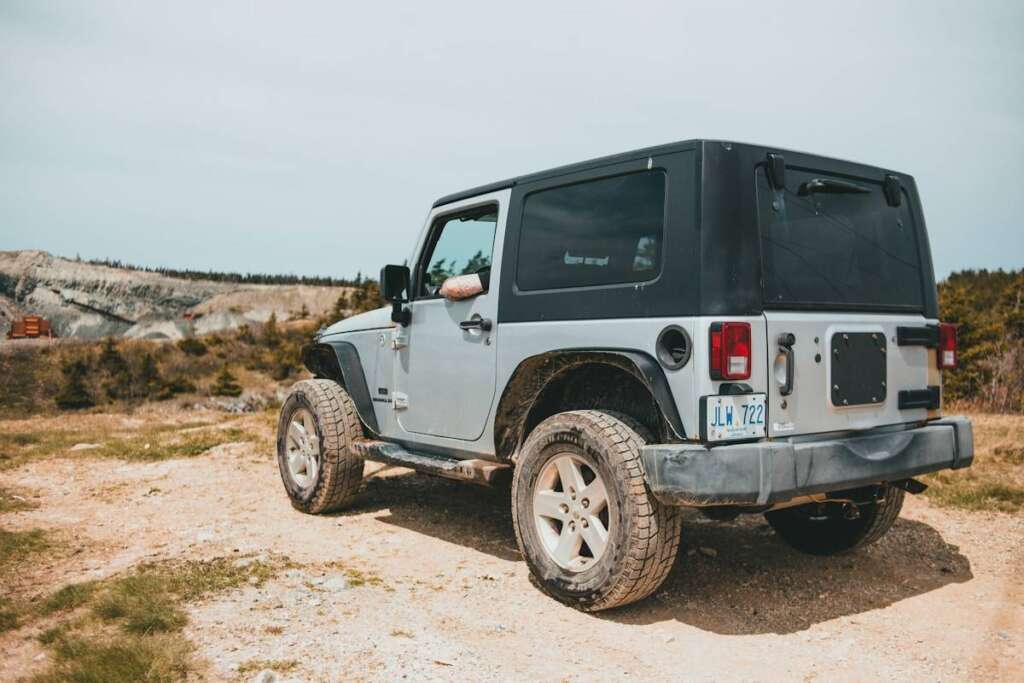 black and white jeep wrangler on brown field during daytime